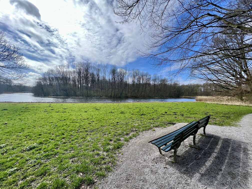 An empty bench in front of a calm river on a sunny day - [Header image for the post: Why I Stopped Tracking Traffic on My Personal Sites - I was never happy about being tracked, why should I do that to others?]